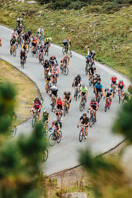 Auf dem Bild erkennt man viele Radfahrer, die beim Ötztaler Radmarathon eine Kurve fahren.