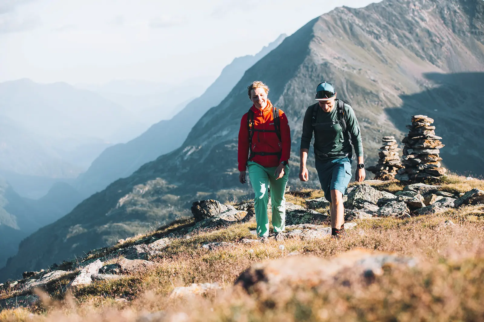 Vier Radfahrer fahren mit ihren Mountainbikes auf einem gewundenen Feldweg durch ein üppig grünes Waldgebiet.